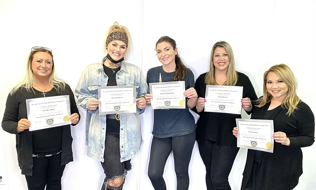 5 students holding their permanent makeup certificates
